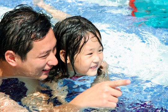 父亲和女儿在游泳池里