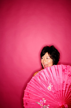 女人背后拿着粉红色伞
