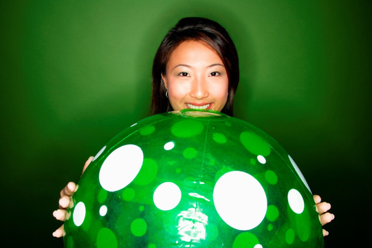 女子抱大绿色充气球