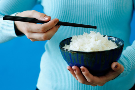 女人抱着大米和筷子碗