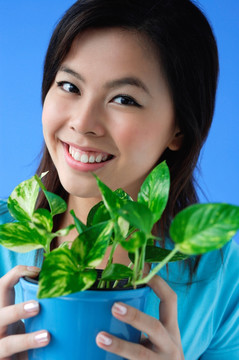 抱植物花盆的年轻女子