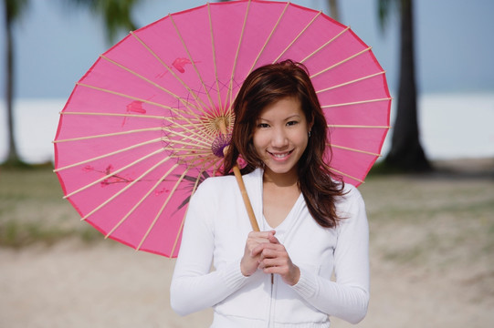 年轻女子使用粉红色雨伞
