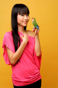 年轻的女人抱着鹦鹉