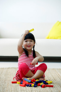 一个小女孩在地板上玩积木