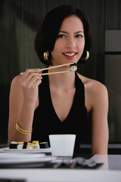 一个女人在吃寿司的时候看着镜头