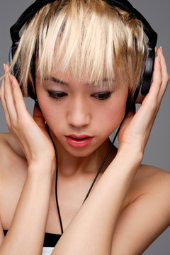 一个戴着耳机听音乐的年轻女人