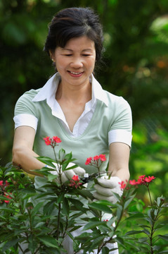 一个女人在花园里修剪花