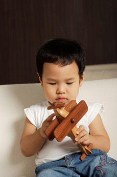小男孩玩木制玩具飞机
