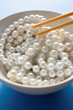 从碗里采摘一串珍珠的筷子