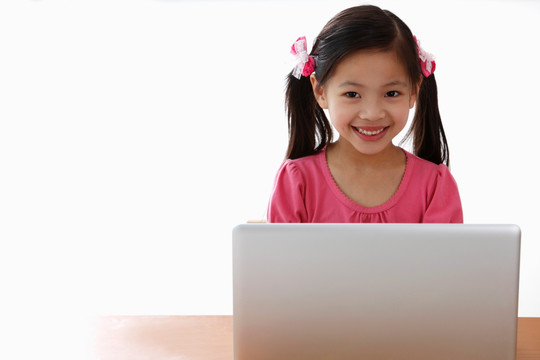 年轻的中国女孩在笔记本电脑上玩