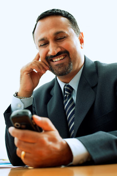 微笑着看着手机的商务男人