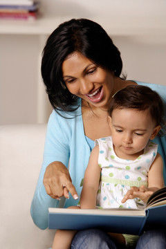 在教婴儿看图画书的女人