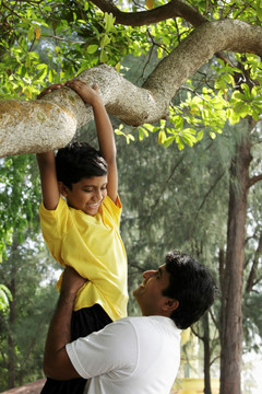 父亲帮助儿子爬上树