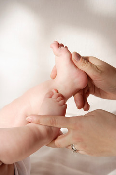 双手抱着婴儿的脚