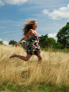 在草地上奔跑的年轻女子