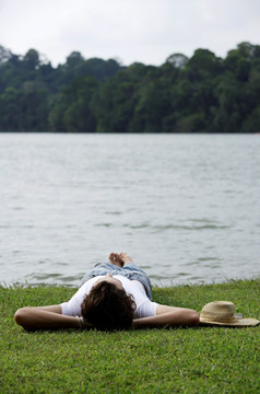 躺在湖边的草地上的年轻人