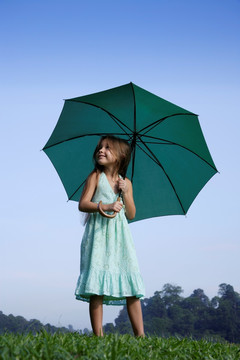 带着绿色雨伞的年轻女孩