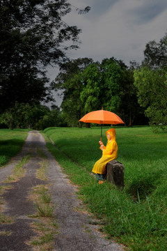 小男孩带着橙色的雨伞