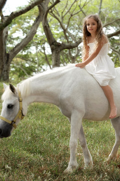 年轻的女孩骑无鞍的小马