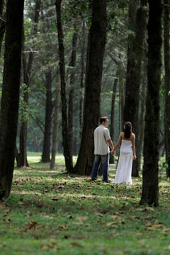 在树林里牵着手散步的夫妇