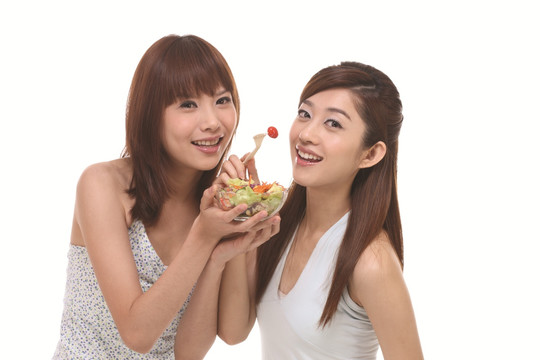在吃蔬菜沙拉的两名女子