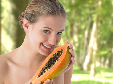 微笑的女人拿着一个木瓜