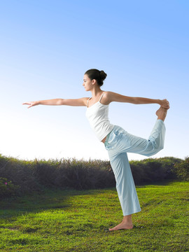 站在草坪上练习瑜伽的女人