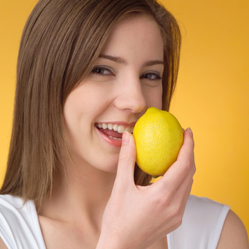 微笑着拿着柠檬的女人