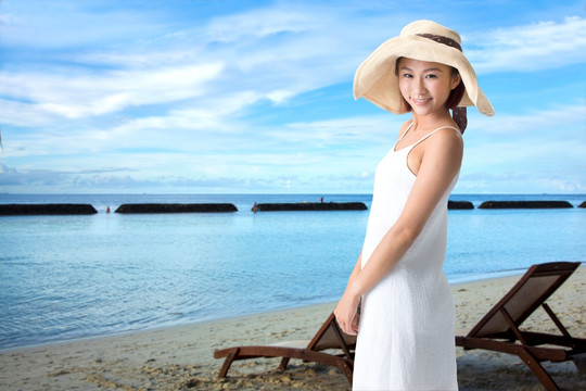 穿着白色连衣裙在海边度假的女人