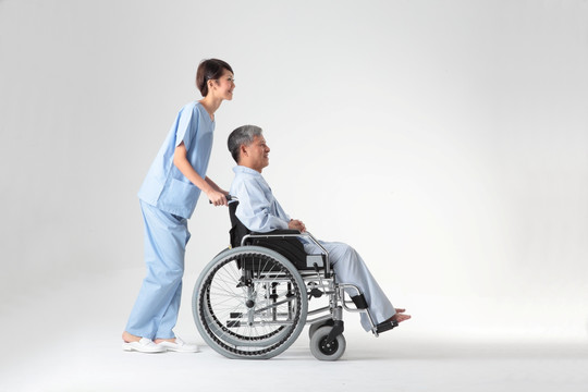 护士推着坐轮椅的病人