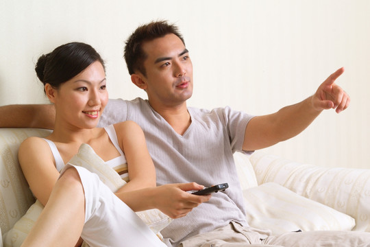坐在沙发上看电视的夫妇