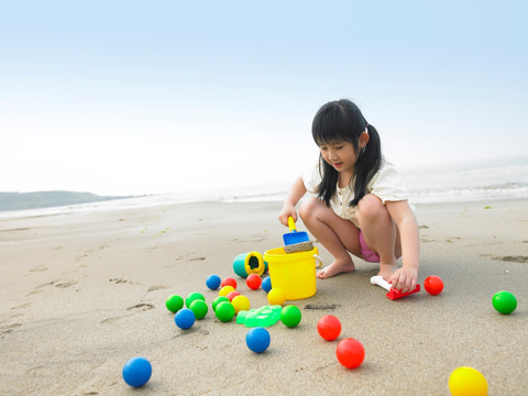 在沙滩上玩玩具的女孩