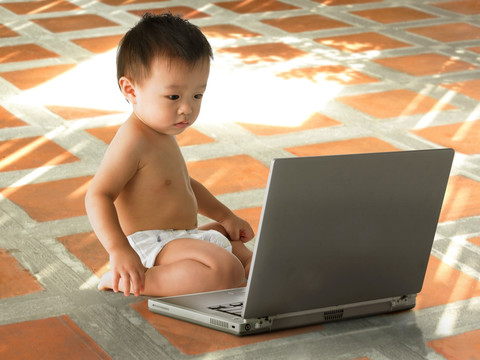 看着笔记本电脑屏幕的婴儿