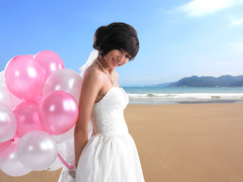 在海边拿着气球泡的新娘