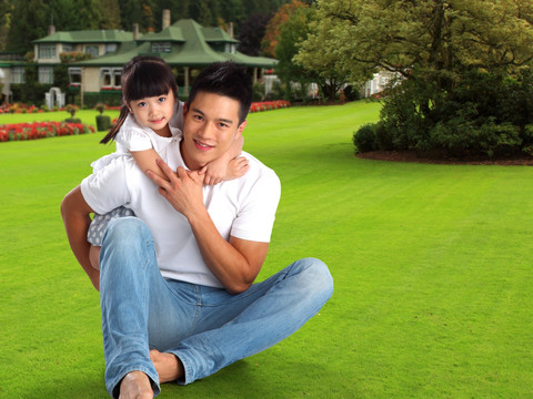 在草坪上的父亲和女儿