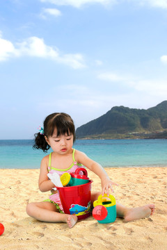 在沙滩上玩玩具的小女孩