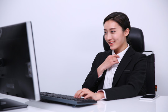 微笑着在电脑上工作的女人