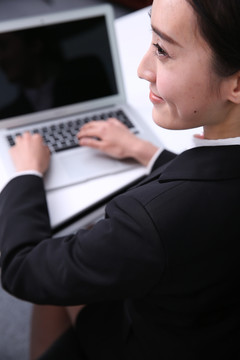 微笑的女人在用笔记本电脑