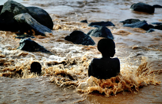 非洲洪水中男孩剪影