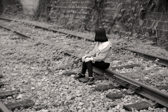 坐在铁轨上的少女