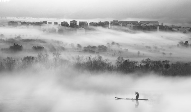晨雾中的村庄与江面上的竹筏