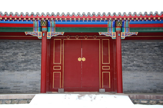 中式双开大红门的雪景