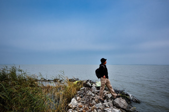 男人站在水边看风景