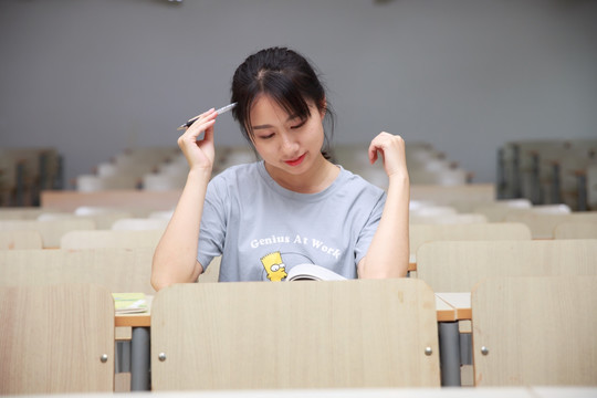 在教室里看着书思考的女学生