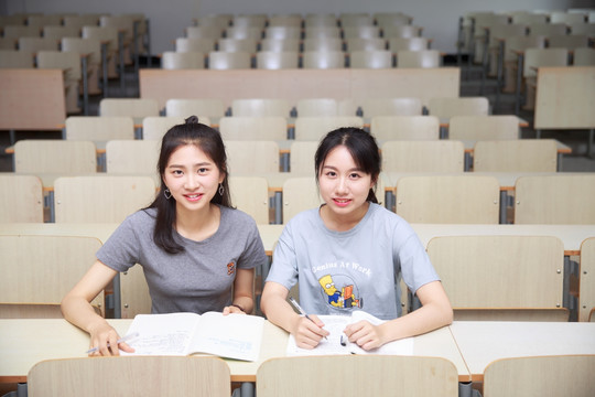 坐在大学教室里学习的两名女大学生