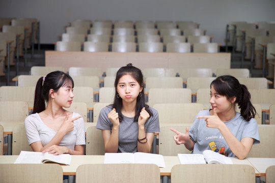 微笑着做着手势的女学生们