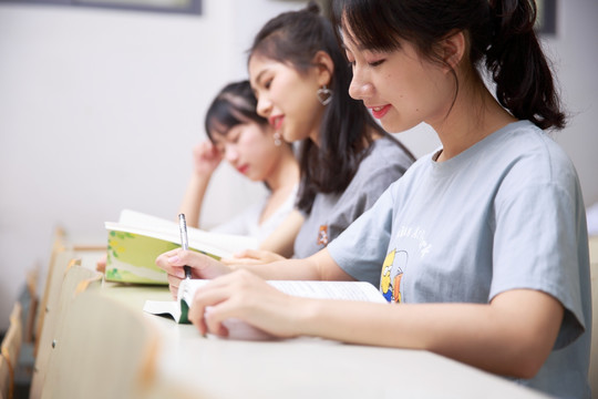 坐在教室里微笑着做作业的女学生