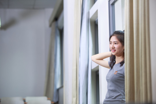 女学生站在窗前微笑着