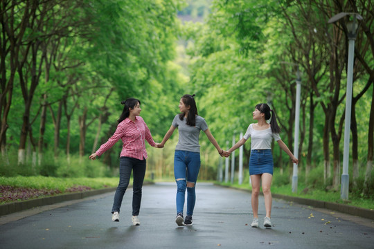 女学生们微笑着拉着手散步