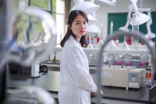 站在实验室里看着前方的女学生